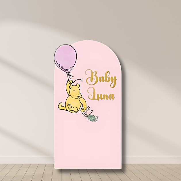 Winnie the Pooh baby shower pink arch backdrop with balloon and personalized name “Baby Luna.”