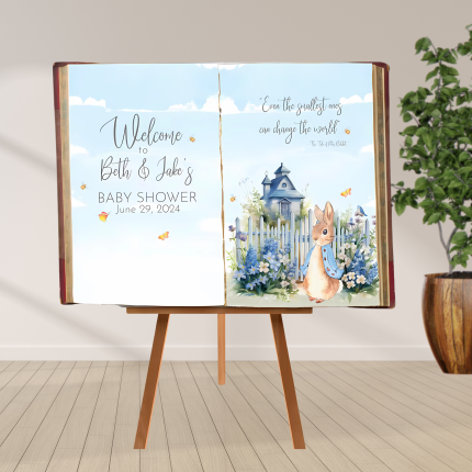 Peter Rabbit storybook baby shower backdrop with open book design, blue florals, and personalized welcome message.