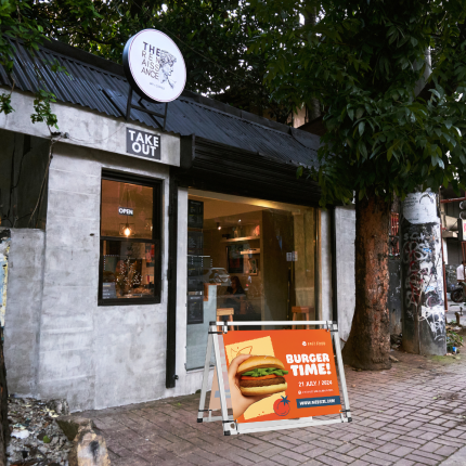 Custom aluminum A-frame with a burger banner in front of takeout restaurant