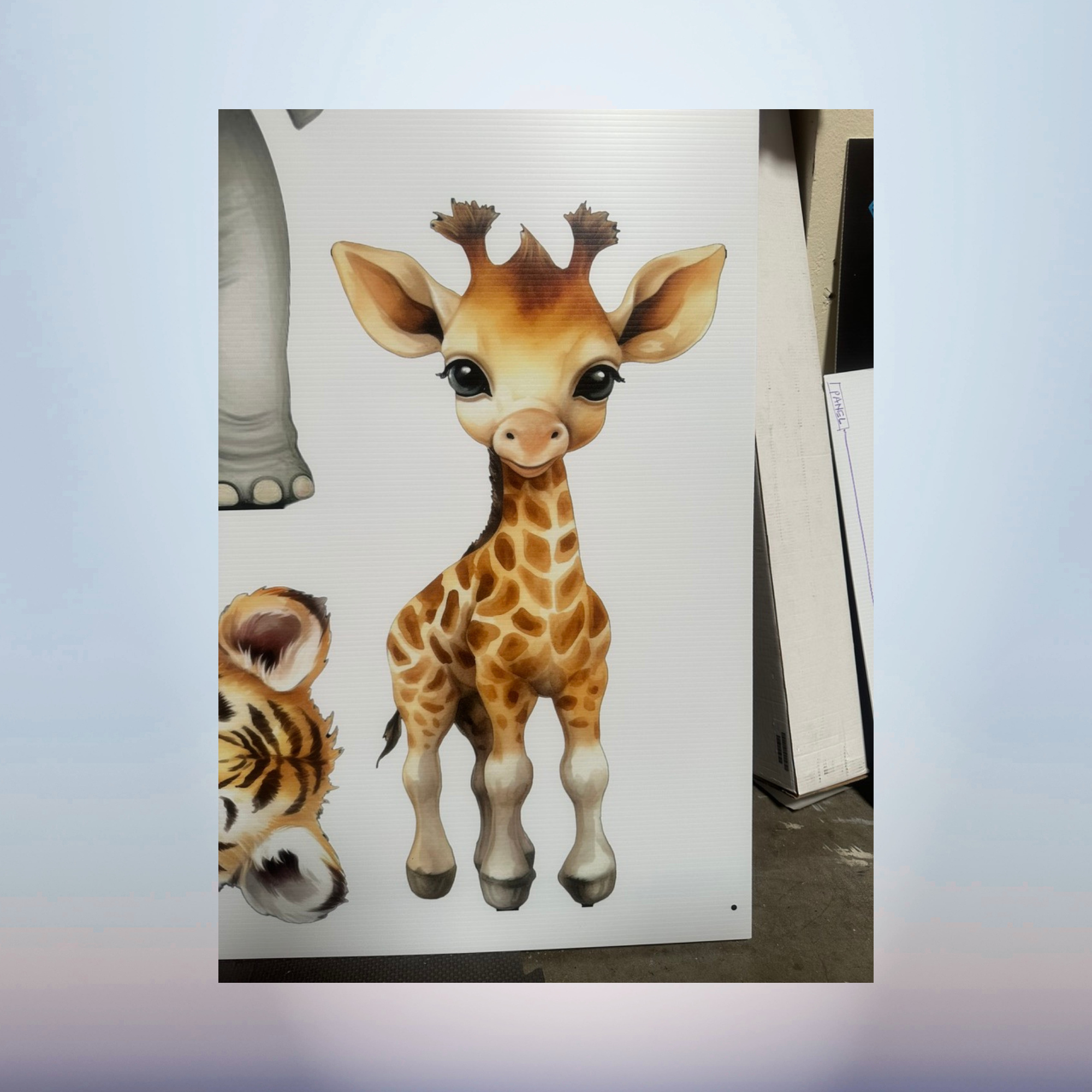 Baby giraffe and tiger character cutouts for a safari baby shower display