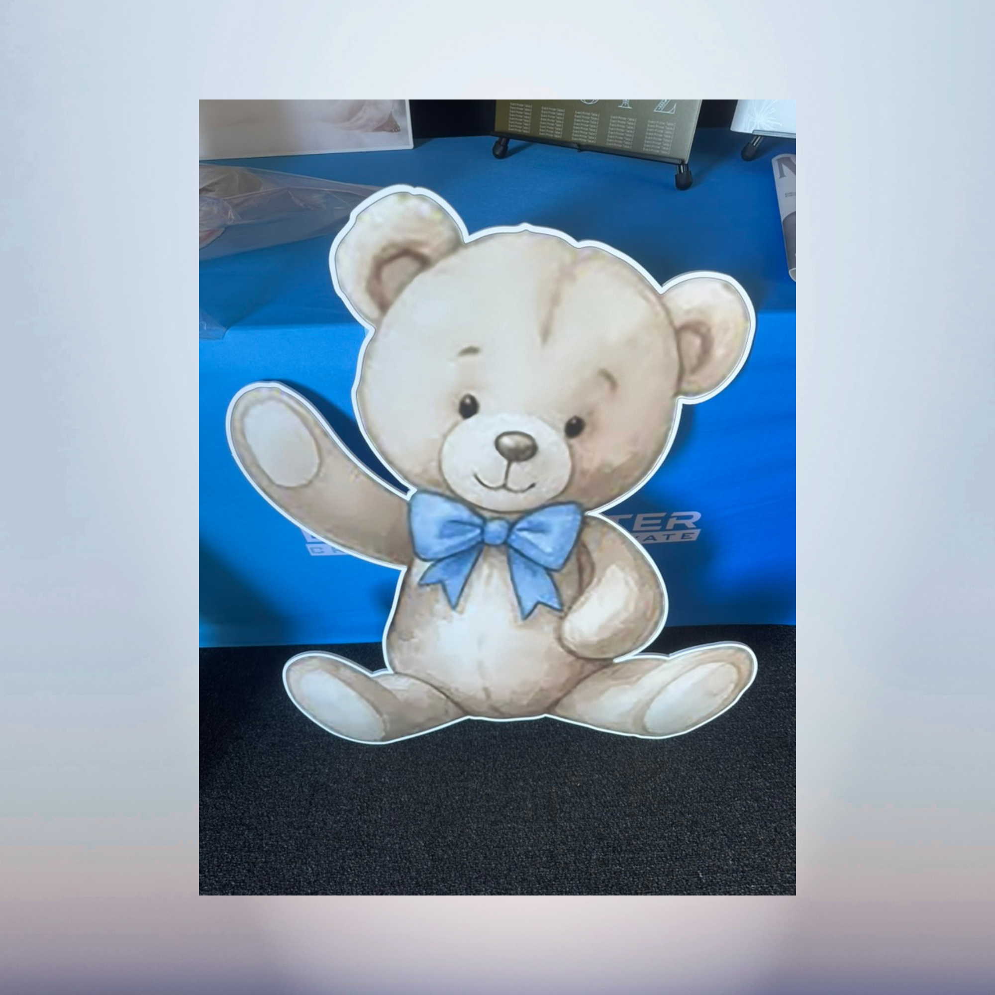 Cute baby teddy bear cutout with blue bow for baby shower decorations