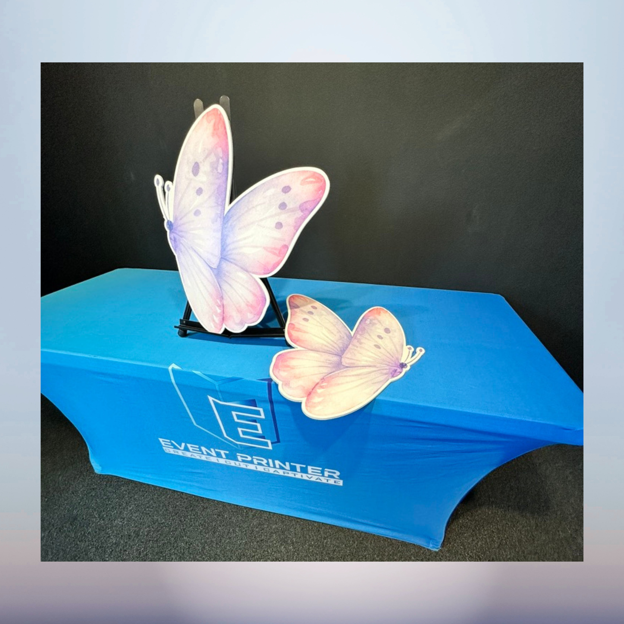 Large pastel pink butterfly cutouts displayed as baby shower decorations