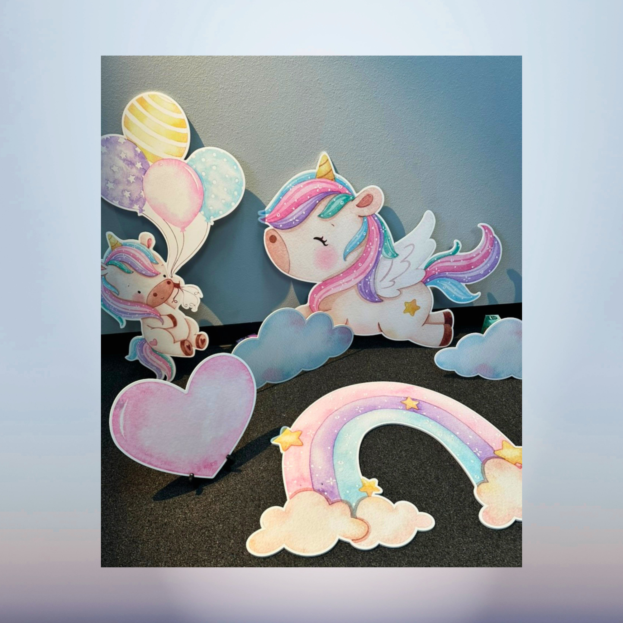 Pastel unicorn rainbow heart and candy character cutouts for a baby shower