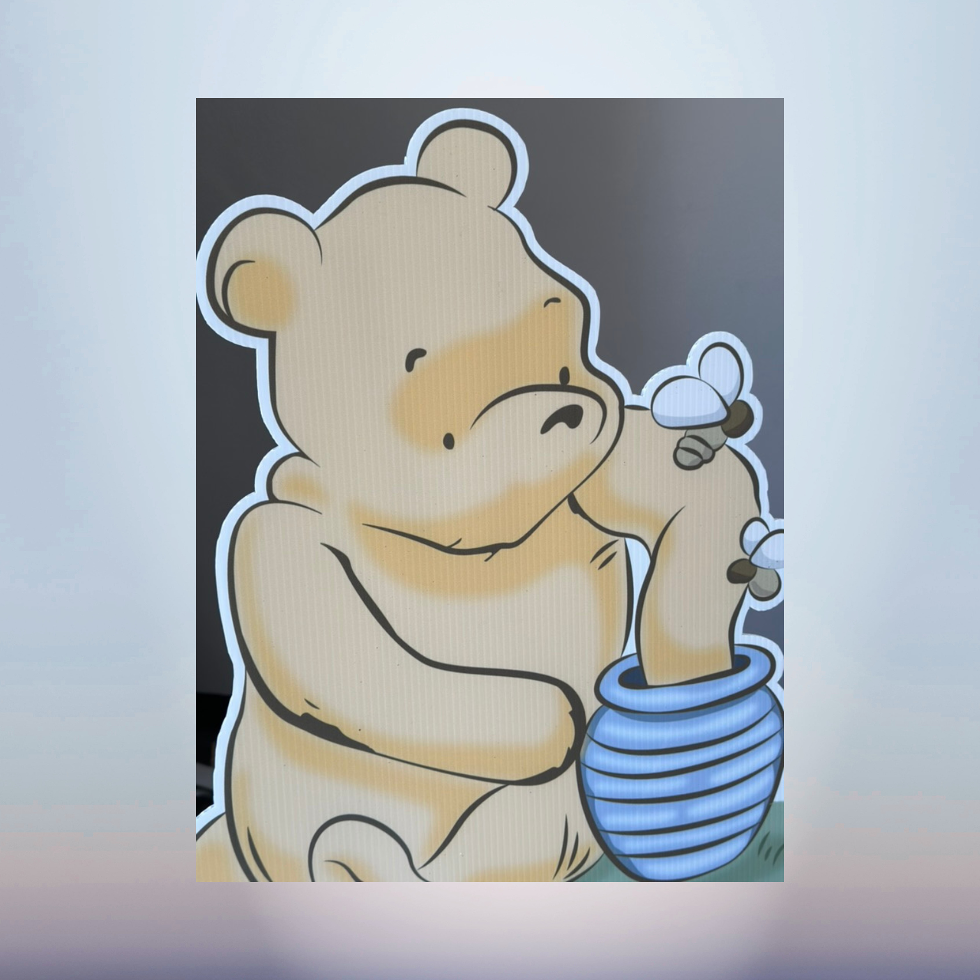 Winnie the Pooh character cutout with striped honey jar for a baby shower