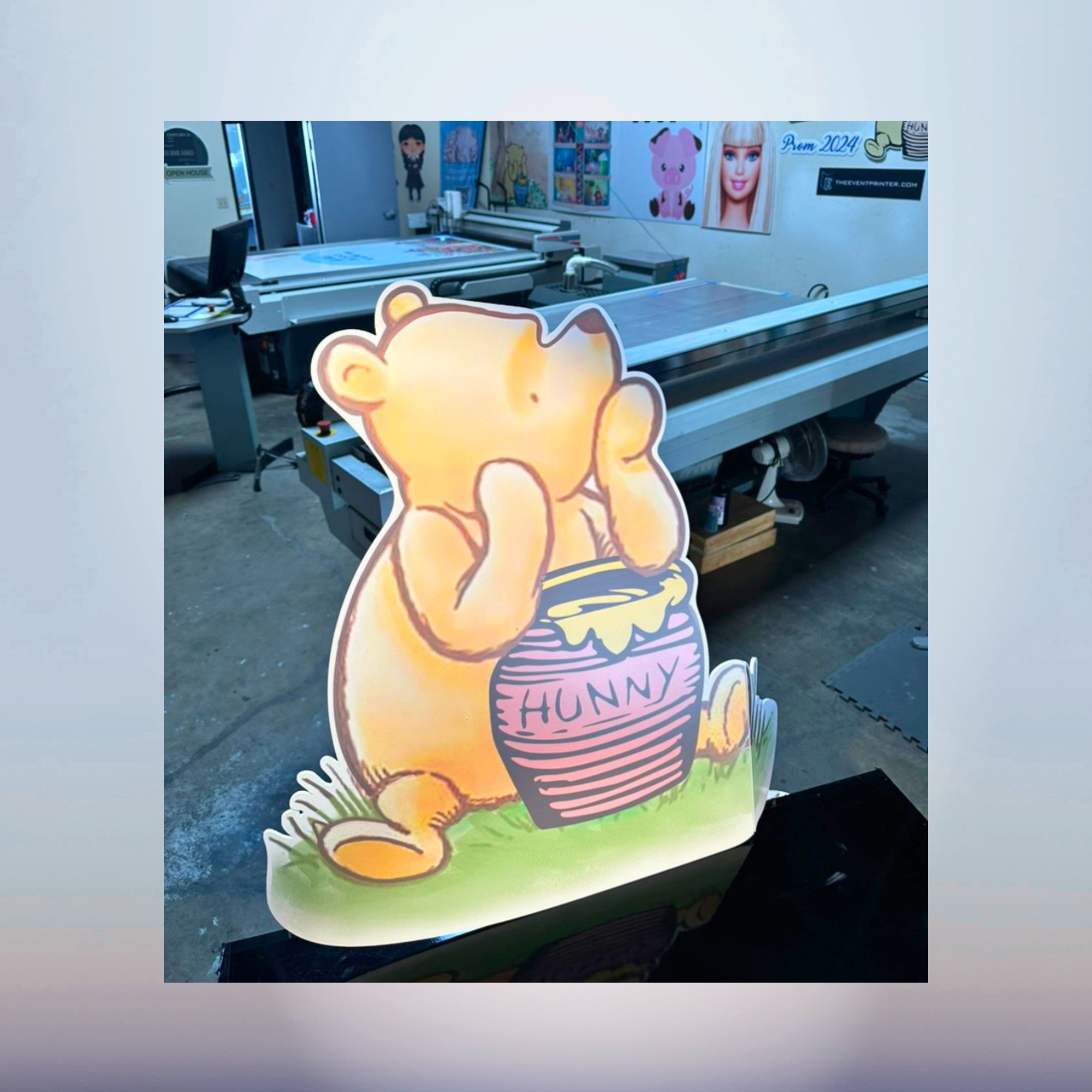 Winnie the Pooh standing with honey pot character cutout for a baby shower